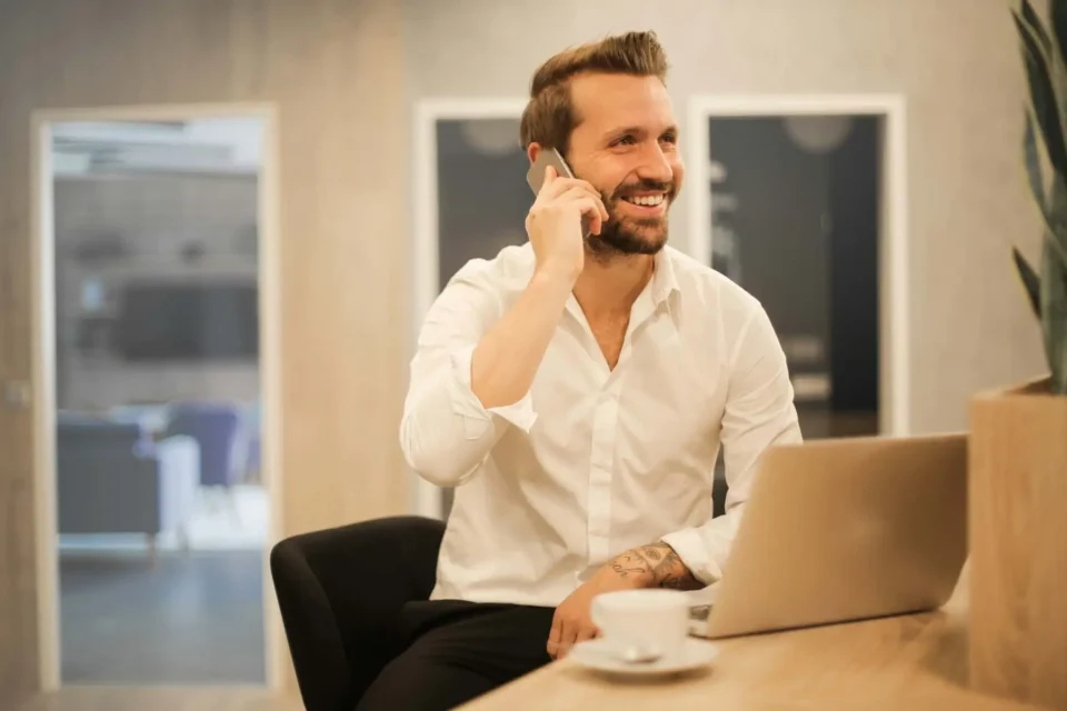 A man on a phone and using a laptop
