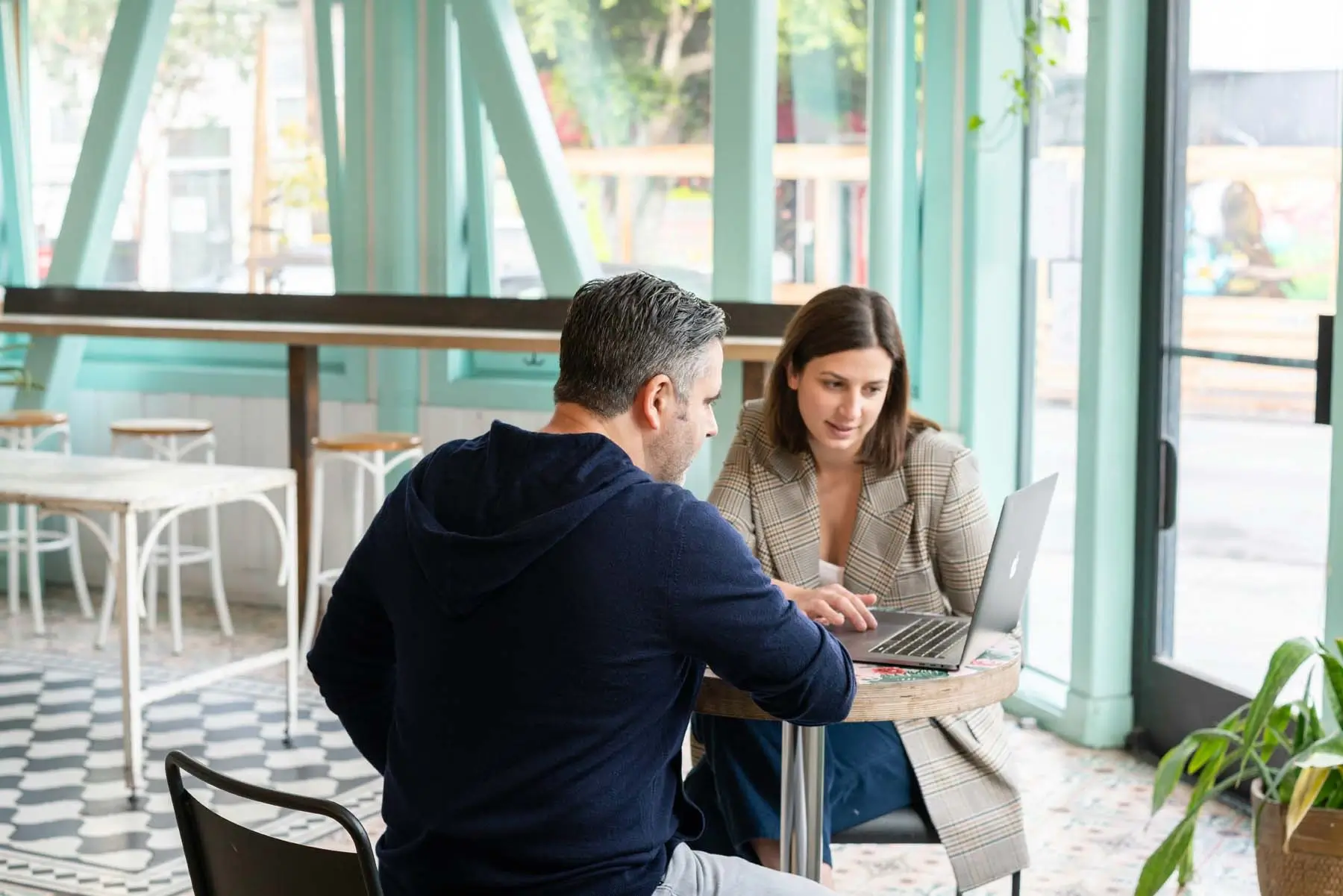 Two people in discussion with a laptop