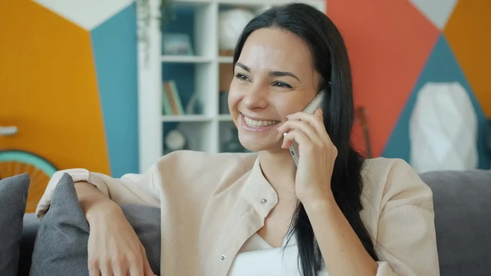 A smiling woman using a phone
