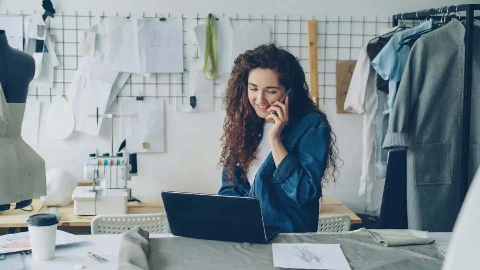 A woman on the phone and using a laptop
